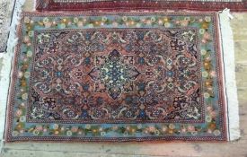 Persian wool rug, red ground, blue border with floral decoration and central flower medallion, 138 x
