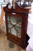 Georgian mahogany hanging corner cupboard, having broken swan-neck pediment over an astragal bar