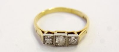 18ct gold and platinum three-stone diamond ring, having central diamond flanked by two slightly