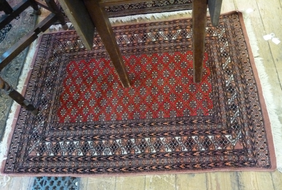 Pakistan wool rug, orange ground, black geometric borders, red central rectangle with geometric