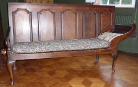 Eighteenth century oak settle/bed, with panelled back, scroll arms on cabriole supports and pad feet
