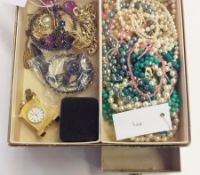 Quantity of assorted bead necklaces, gilt bracelets, a small gilt clock, all held within a cardboard