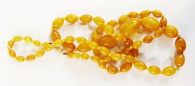 String of graduated egg yolk coloured amber type beads, oval