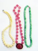String of pink beads, string of mottled green beads and string of ivory coloured beads