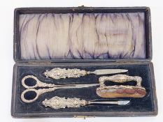 Edwardian silver mounted manicure set, rococo repousse, viz: pair scissors, nail buffer and two nail