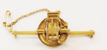 Gold-coloured metal bar brooch in the form of loop, buckle and tassel