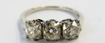 White metal  and three stone diamond ring, each of he three old cut stones claw set