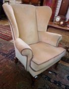 Wingside easy chair, in beige upholstery on cabriole legs