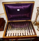 Cased set of fruit knives, engraved blades, with mother-of-pearl handles, small finials to the