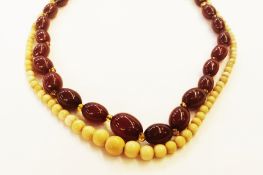 String of red amber-coloured graduated beads and an ivory bead necklace, graduated (2)