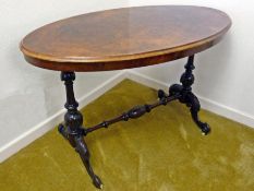 A Victorian oval figured walnut veneered stretcher table, having ogee moulded rim on turned and