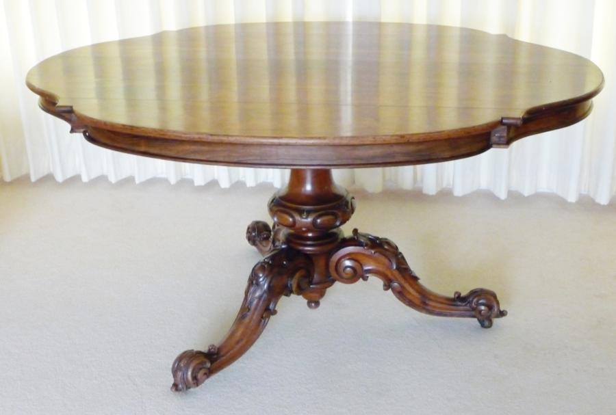 Victorian rosewood veneered loo table, the shaped top raised on carved and turned pedestal and