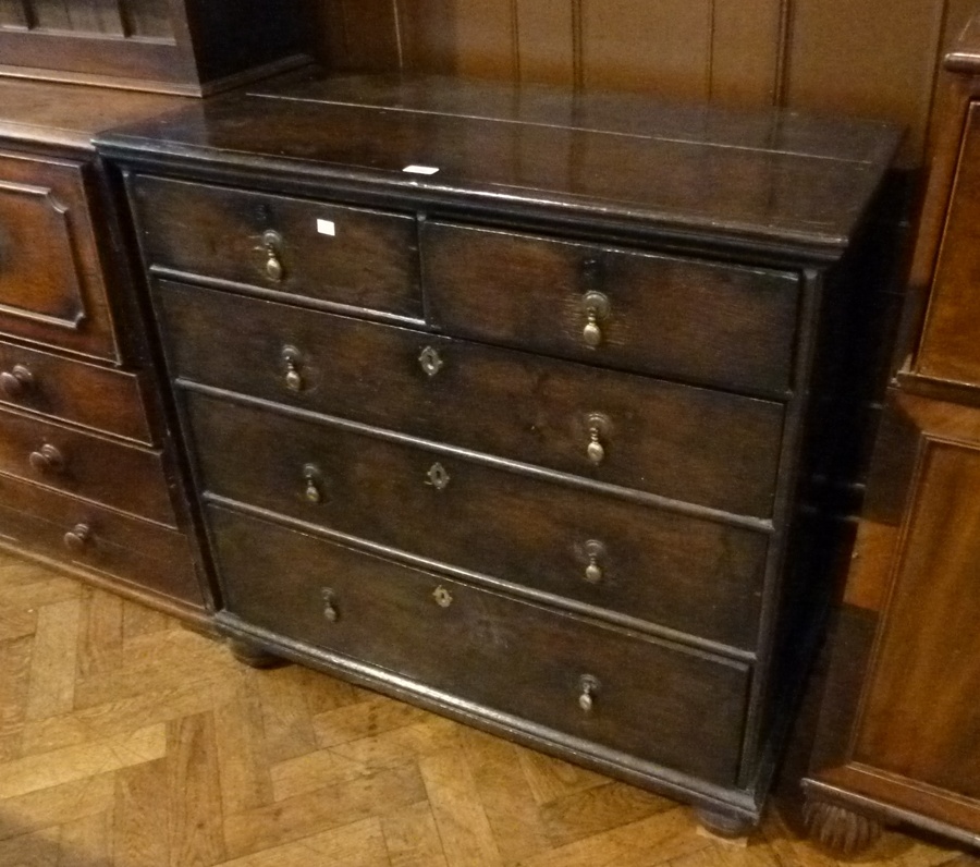 Eighteenth century oak chest of two short and three long graduated drawers, brass drop handles, on
