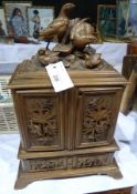 Black Forest carved walnut table cabinet with partridge surmount, a pair of foliate carved