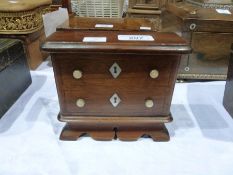 A mahogany money box in the form of a miniature chest of drawers, with two dummy drawer fronts,