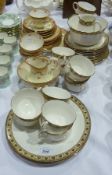 Part tea service, cream ground with yellow border and black scroll and  foliate decoration and a