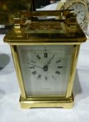 A modern English carriage clock timepiece with brass case with bevelled glazed panelled sides,