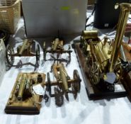 A brass replica model of a Stephenson's Rocket mounted on a wooden plinth, together with three model