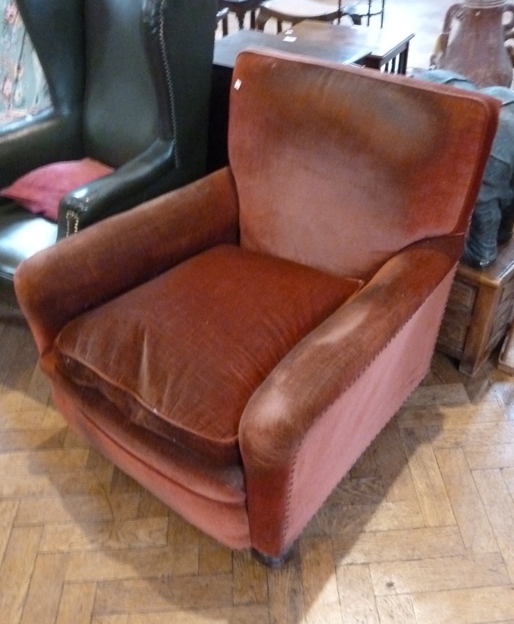 Armchair, with loose cushioned seat, red dralon upholstery, on bun feet with castors