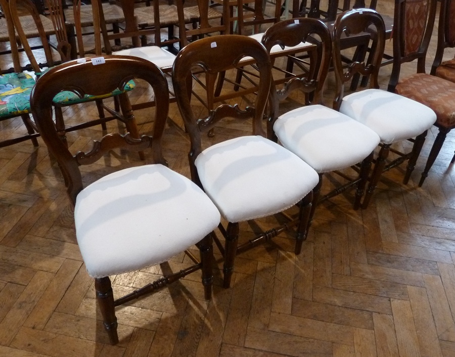 A set of four Victorian stained beech balloon back dining chairs, with scroll carved splat,
