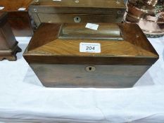 A nineteenth century rosewood sarcophagus shaped tea cadddy, the interior fitted with two