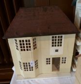 A Tri-Ang wooden dolls house with a hinged front, with red front door