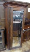 A mahogany single wardrobe with mirrored door, dentil cornice to top, enclosing hanging space,