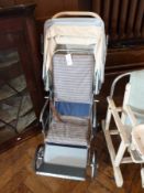 A vintage metal pushchair with footrest, plastic folding hood