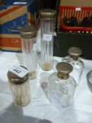 Five assorted  and variously sized silver-topped glass jars