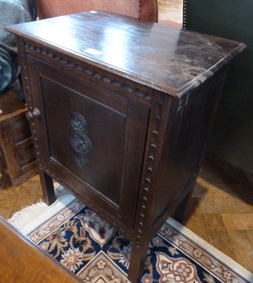20th century oak single cupboard, with carved panelled door on square supports, 53cm wide