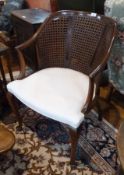 Twentieth century cane back open armchair, with cream stuff-over seat, on cabriole supports