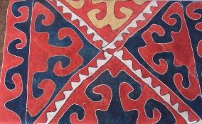 WITHDRAWN

A multi coloured wool rug, with central medallions with wavy patterns in a red field