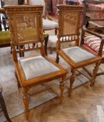 Pair oak and cane carved chairs, carved and cane backs with upholstered and studded seats, on turned