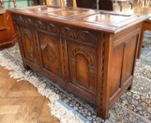 Reproduction polished oak coffer of triple frame construction, the front with foliate lunette carved