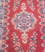 Oriental design wool rug, with red field, central medallion within multiple floral borders