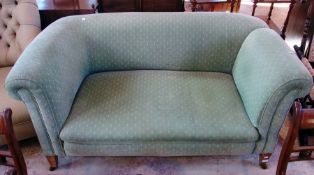Antique drop-end Chesterfield settee, in green upholstery, on tapering supports and castors