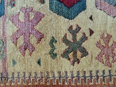 An Egyptian Oriental weaver's gabbeh rug with stylised geometric designs within a beige field with