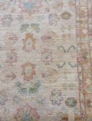 Two Pakistan style (?) wool rugs, cream ground with orange and blue faded motifs (2)