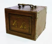 An old mah jong set in brass bound wooden cabinet with carrying handles, the front panel rising to