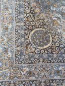 A Persian design wool rug, with floral central medallion within a blue field, overall floral