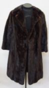 A full length black mink coat, half belt on the back