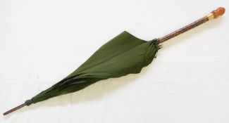 Green silk umbrella with faux bamboo handle, faux amber finial with a gold-coloured and paste collar