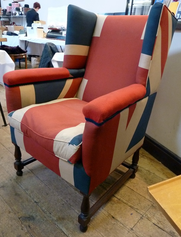 Early twentieth century wing armchair, upholstered in Union Jack flag, on turned supports united