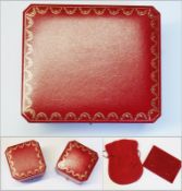 Three various Cartier boxes (one large and two small), and two red leather and fabric pouches