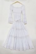 A white mexicana cotton dress with pin-tucks and lace detail with belt