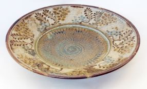 John Calver stoneware dish, in browns and greens, decorated with impressed foliate decoration,