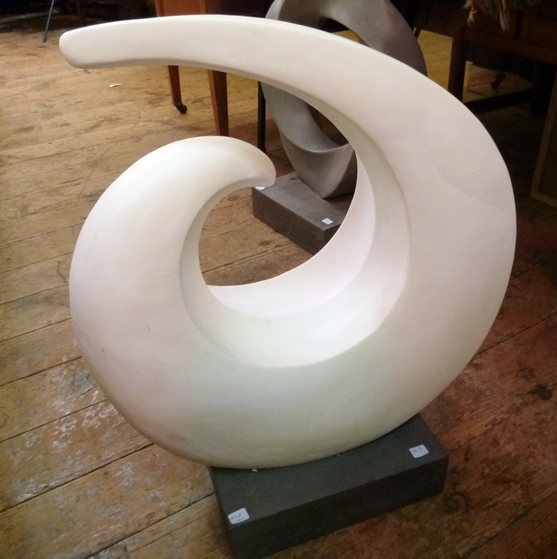 White plaster, free-form, circular, curled sculpture, on a grey resin plinth, 64cm high