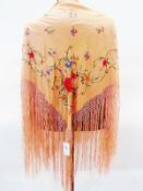 Oriental embroidered shawl, floral decorated peach-coloured, with tasselled fringing, another, cream