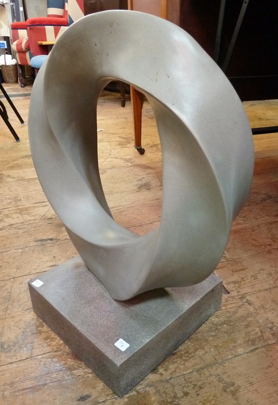 Grey resin circular, twisted sculpture on a grey resin plinth, 61cm high approx.