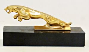 Gold-coloured metal Jaguar car mascot, mounted on black rectangular plinth base, 13cm in length